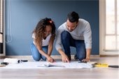 Couple with plans spread out on the floor