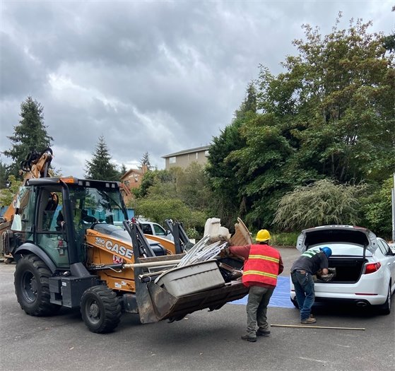 Case tractor with bucket on front filled with materials to recycle