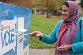 Voter placing ballot in drop box